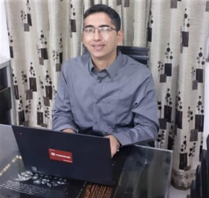 Prakash Assudani smiles at the camera while working from his home office.